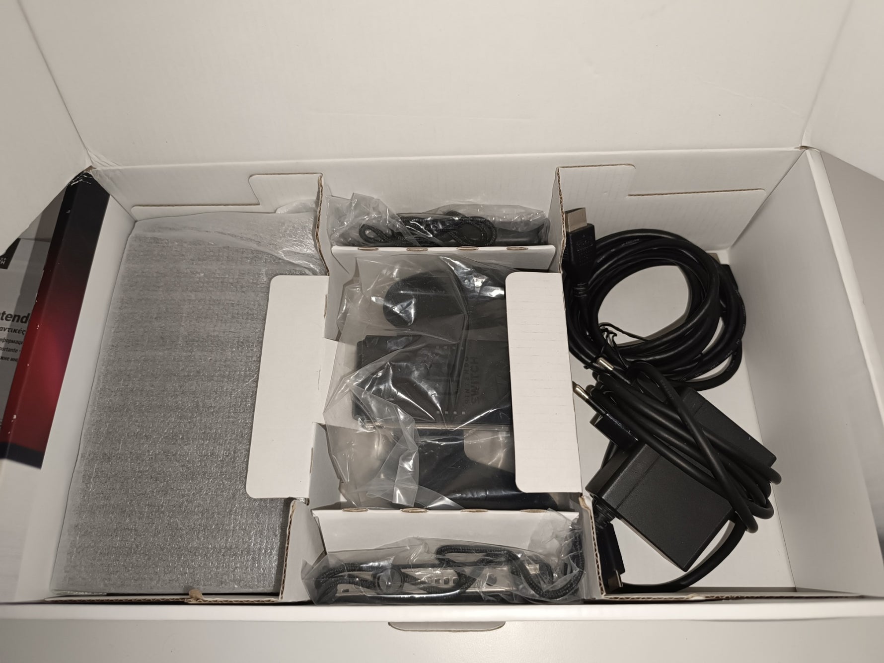 Unpacked Nintendo Switch cables and accessories inside a box
